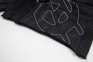 Detailed view of washed vintage black casual shorts featuring contrast white embroidery design.