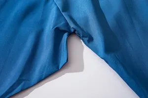 Blue fabric garment sewing detail close up showing stitching and textile texture.