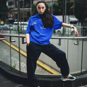 Urban streetwear t-shirt detail shot, blue graphic tee with letter print and relaxed fit.