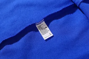 Blue cotton t-shirt detail show with size L label and wash instructions clearly visible.