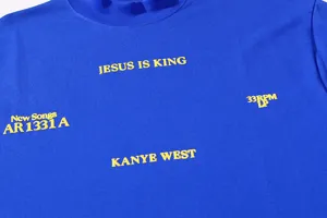 Detailed view of the blue t-shirt showcasing yellow graphic prints and chest text design clearly.