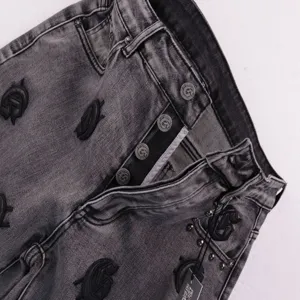 Distressed black denim shorts with custom logo buttons and black embroidered letters streetwear.