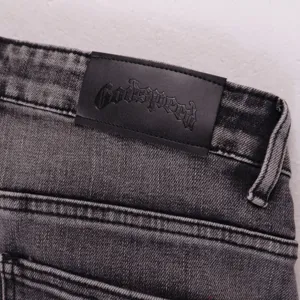 High street casual washed denim shorts with black leather logo patch, premium streetwear style.