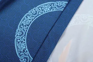 Detail view of Japanese kimono fabric showing blue swirl and elegant floral traditional patterns.