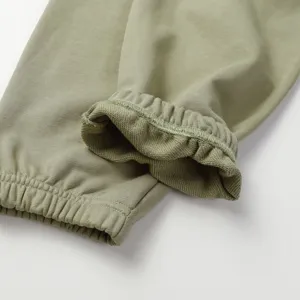 Olive green sweatpants detail shot showcasing ribbed cuffs and neat stitching quality.