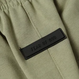 Detailed view of casual sweatpants featuring an embossed rubber logo patch for stylish streetwear.