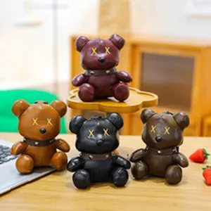 Detailed view of trendy leather bear figurines with iconic cross eyes and studded collar decor.