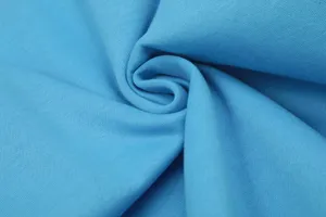 Primo piano dettagliato della trama del tessuto in morbido cotone blu chiaro a spirale.
