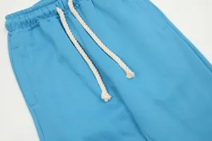Dettaglio pantaloni tuta blu casual, comodo girovita con coulisse e tessuto morbido.