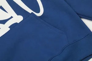 Blue fleece hoodie detail with front pocket and white graphic lettering for street style.
