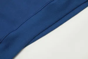Detailed shot of the blue hoodie ribbed hem, showing fine fabric texture and neat stitching.