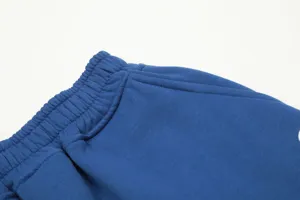 Close-up detail of blue fleece shorts waist and pocket, showing fine stitching and fabric texture.