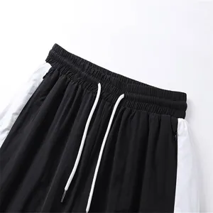Close-up detail of black and white color-blocked casual shorts with drawstring waistband.