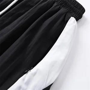Close-up detail of casual shorts featuring contrast color-blocking and adjustable drawstring waist.