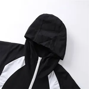 Close-up detail of black and white colorblock hooded windbreaker jacket with zipper.