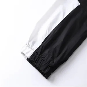 Black and white colorblock windbreaker sleeve or pant detail, stylish streetwear apparel.