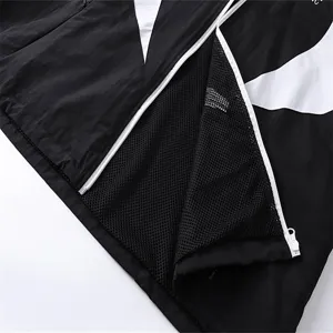 Detail shot of black and white colorblock windbreaker jacket zipper and mesh lining design.