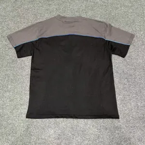 Detailed view of the color-block short-sleeve t-shirt with grey and black patchwork design.