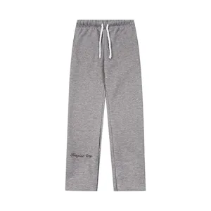 Pantalone della tuta grigio felpato in dettaglio, con coulisse bianca e stampa con lettere.