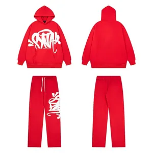 Vista dettagliata del set felpa e pantaloni streetwear rossi con scritta graffiti bianca.