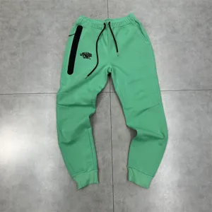 Detailed view of green fleece casual sweatpants with black zipper pocket and adjustable drawstring.