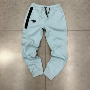 Detailed view of casual light blue fleece joggers with black drawstring and zip pocket.