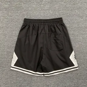 Detailansicht schwarzer Sportshorts mit weißen Seitenteilen, Gesäßtasche und elastischem Bund.