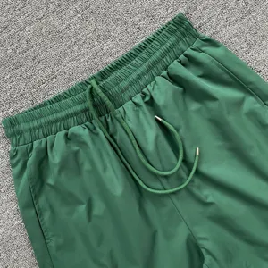 Detailaufnahme grüne Freizeitsportshorts, elastischer Kordelzugbund, bequeme Passform.