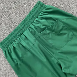 Detailansicht grüner Sportshorts mit elastischem Bund und praktischer Gesäßtasche.