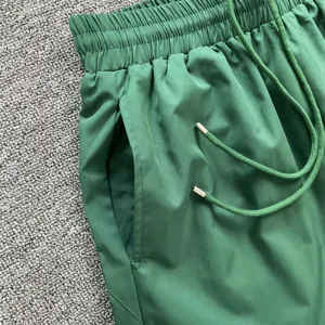 Grüne Freizeitshorts Detail, elastischer Kordelzug Bund und praktische Seitentasche.