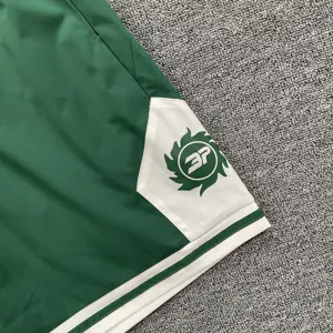 Nahaufnahme von grün-weißen Mesh-Sportshorts mit Farbblock und BP-Buchstaben-Logo.