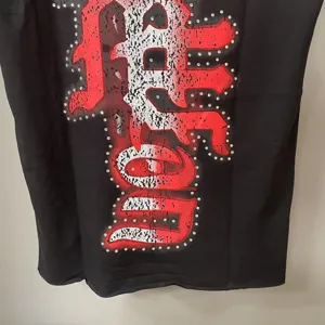 Unisex streetwear aμάνικο γιλέκο με μοντέρνο γραφικό σχέδιο και λαμπερές λεπτομέρειες στρας.