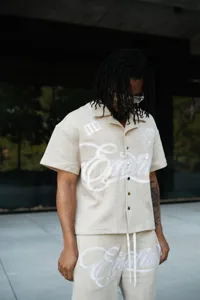 Detailed view of beige waffle knit short sleeve shirt and shorts set with stylish embroidery.