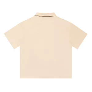 Close-up back view of a solid beige waffle knit short-sleeve shirt showing fabric texture.