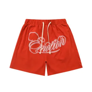 Detailed view of red waffle knit shorts featuring white cursive embroidery and drawstring waist.