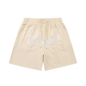 Beige waffle knit shorts with drawstring waist and embroidered front cursive text detail.