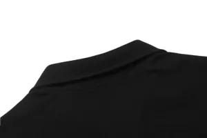 Close-up detail of the black waffle knit polo collar, showing premium texture and neat stitching.