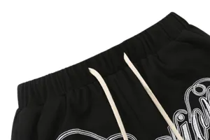 Closeup detail of black waffle knit shorts waistband with adjustable drawstring and embroidery.
