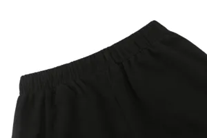 Detailed view of black waffle knit shorts elastic waistband, premium texture and neat stitching.