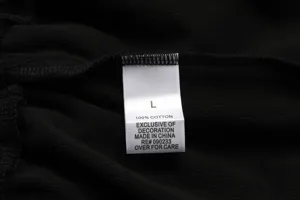 Close-up detail of the inner size and 100% cotton wash label on the black ribbed garment.