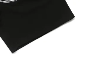 Close-up detail view of black waffle fabric apparel featuring clean white stitching accent.