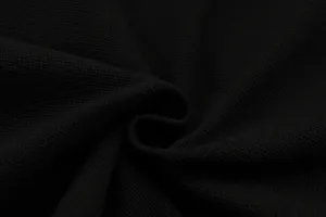 Close-up detail of premium black waffle knit fabric, showing soft texture and fine weaving.