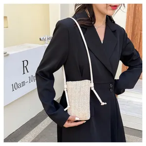 Gros plan sur les détails du sac bandoulière tendance en paille tressée avec une fine lanière.