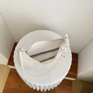 Vue détaillée du sac axillaire en nylon blanc montrant l'ouverture zippée et la chaîne chic.