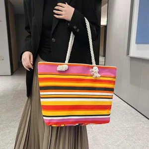 Detailansicht einer modischen gestreiften Canvas-Einkaufstasche mit dicken Seilgriffen.