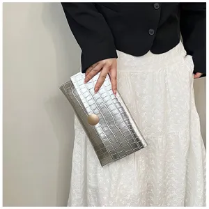 Détail de pochette enveloppe métallisée argentée élégante avec finition texturée.