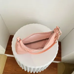 Gros plan détaillé du sac porté épaule rose en nylon montrant l'intérieur et la chaîne.