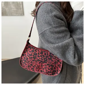 Vue détaillée du sac porté épaule imprimé léopard rouge et noir, design minimaliste.
