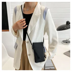 Vue détaillée d'un petit sac bandoulière noir pour téléphone, porté par le mannequin.