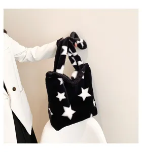 Close-up detail of black fluffy tote bag with white stars, soft plush texture, casual style.